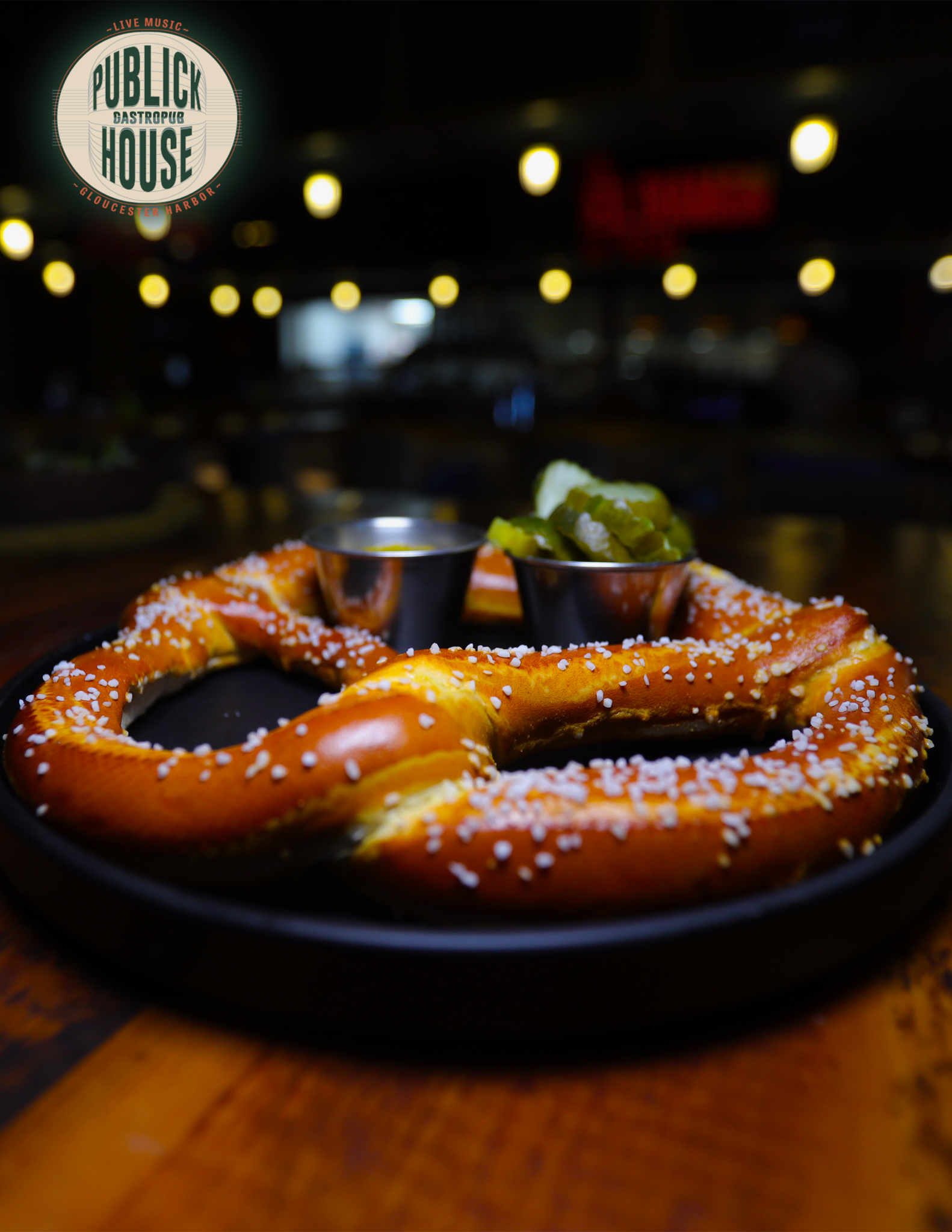 A large golden salted pretzel with dipping sauces at Publick House
